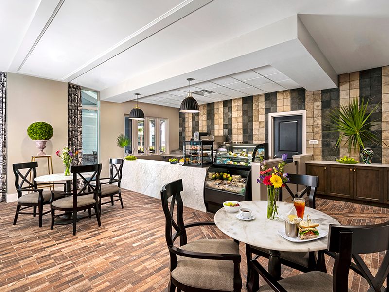A cozy cafe interior with tables and chairs set for dining.