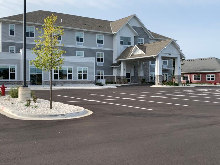 A modern building with an empty parking lot in front.