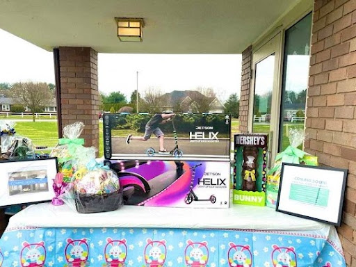 A colorful outdoor setup featuring a variety of gifts and toys, perfect for an Easter celebration.