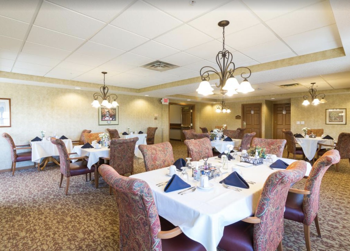 A well-furnished dining room with elegantly set tables and comfortable seating arrangements.