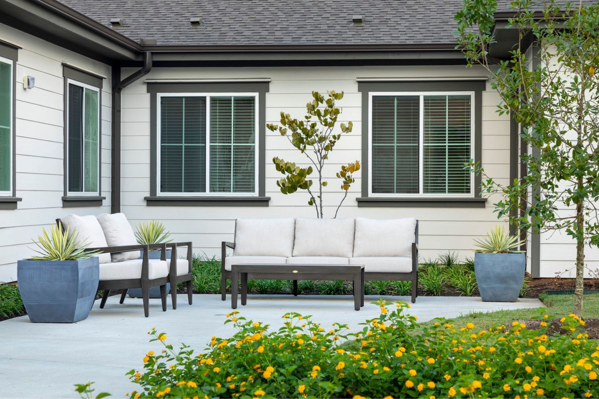 A modern patio setup with outdoor furniture and a well-maintained garden.