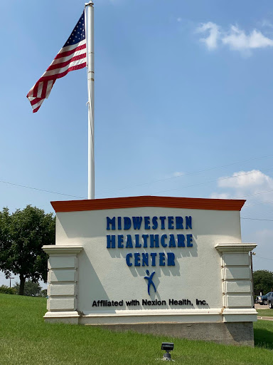 Signage for Midwestern Healthcare Center with an American flag in the background.