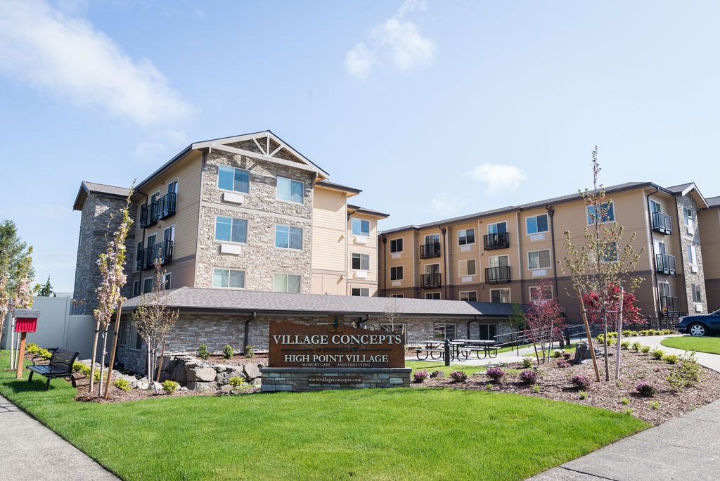 Exterior view of a hotel with landscaped grounds and a prominent sign.
