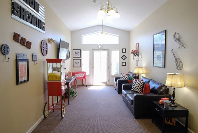 A cozy living room with couches, a popcorn machine, and decorative elements.
