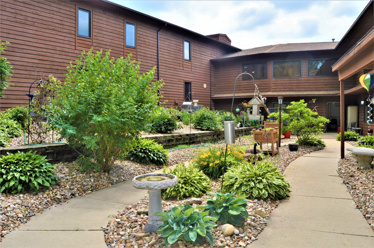 A beautifully landscaped garden with a variety of plants and a stone pathway leading to a building.