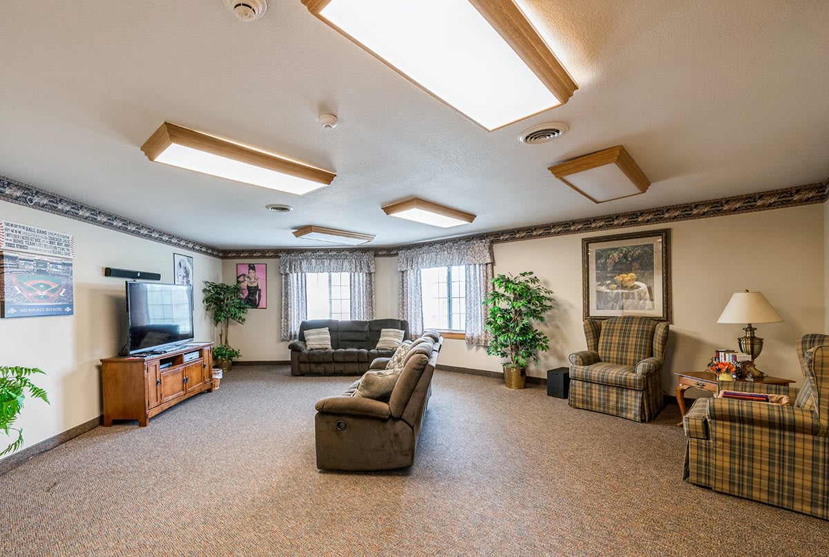 A cozy living room with comfortable sofas, a television, and natural lighting.