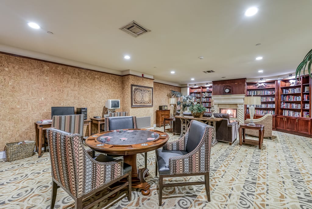 Cozy living room with a round table, upholstered chairs, and a fireplace.