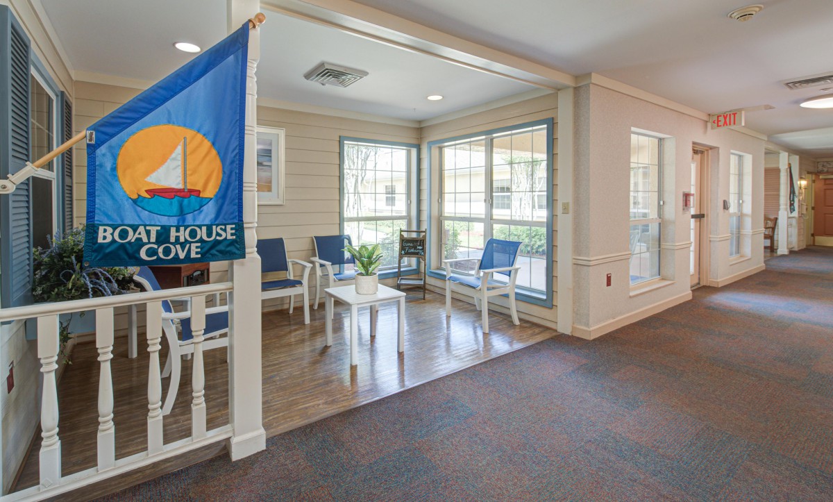 A cozy waiting area with blue chairs and large windows, featuring a decorative flag.