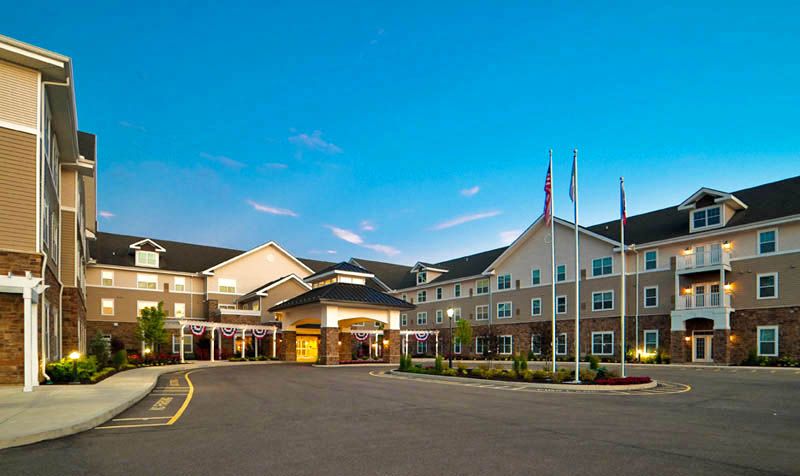 Exterior view of a hotel building with flags at dusk.