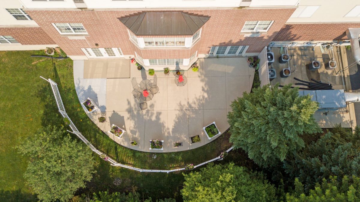 Aerial view of a house patio with landscaping and outdoor furniture.