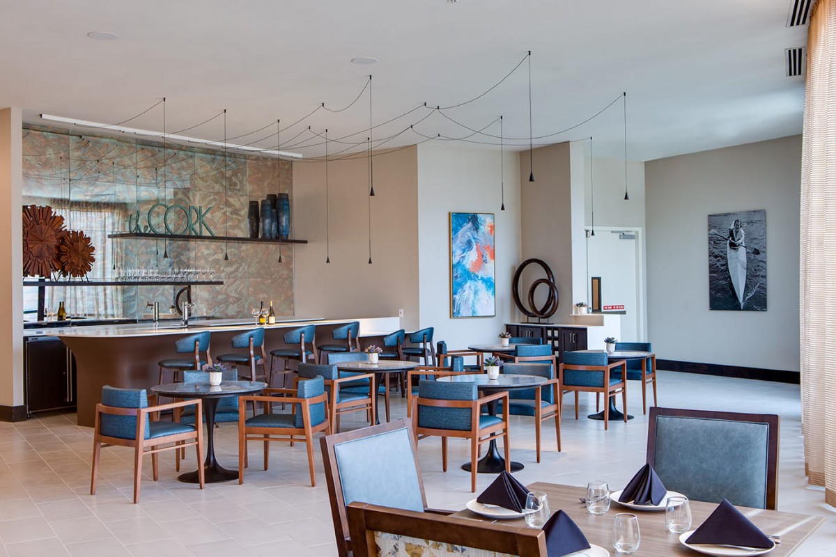A modern restaurant interior with elegant tables and chairs, featuring contemporary art and a stylish bar area.