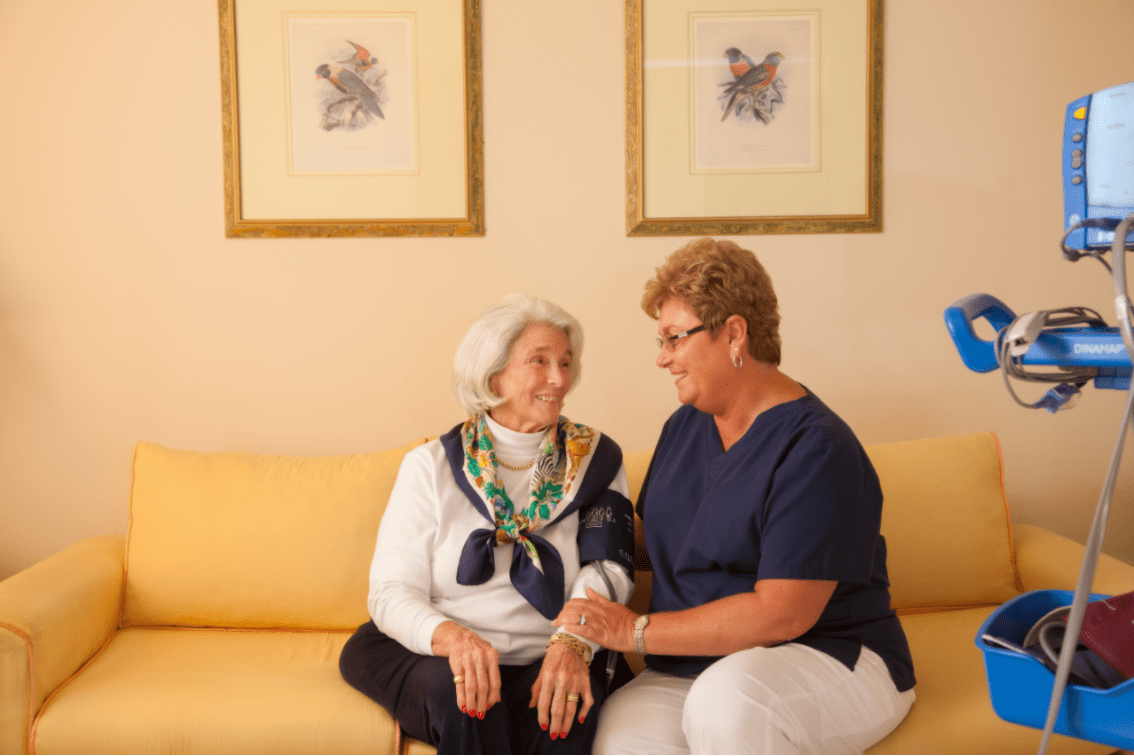 A caregiver provides support to a senior woman, illustrating compassionate elderly care.