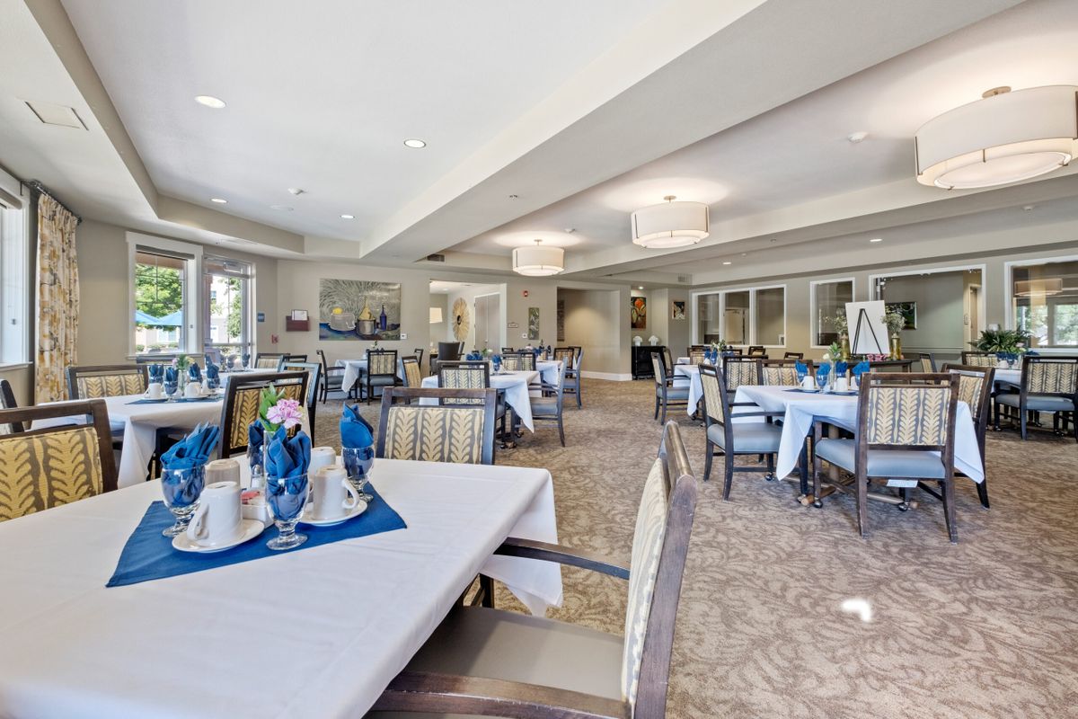 An elegant dining area with neatly set tables and chairs, ready for guests.