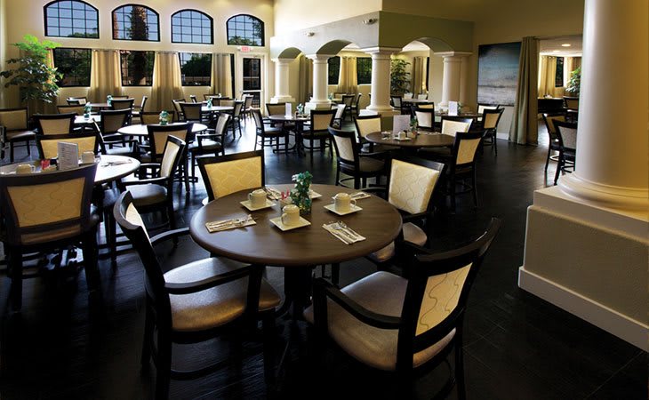 An empty restaurant dining area with neatly arranged tables and chairs.
