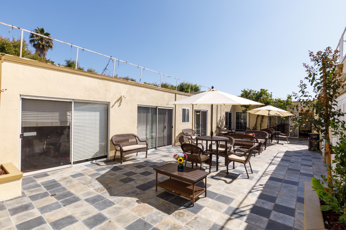 A spacious outdoor patio with seating and umbrellas on a sunny day.