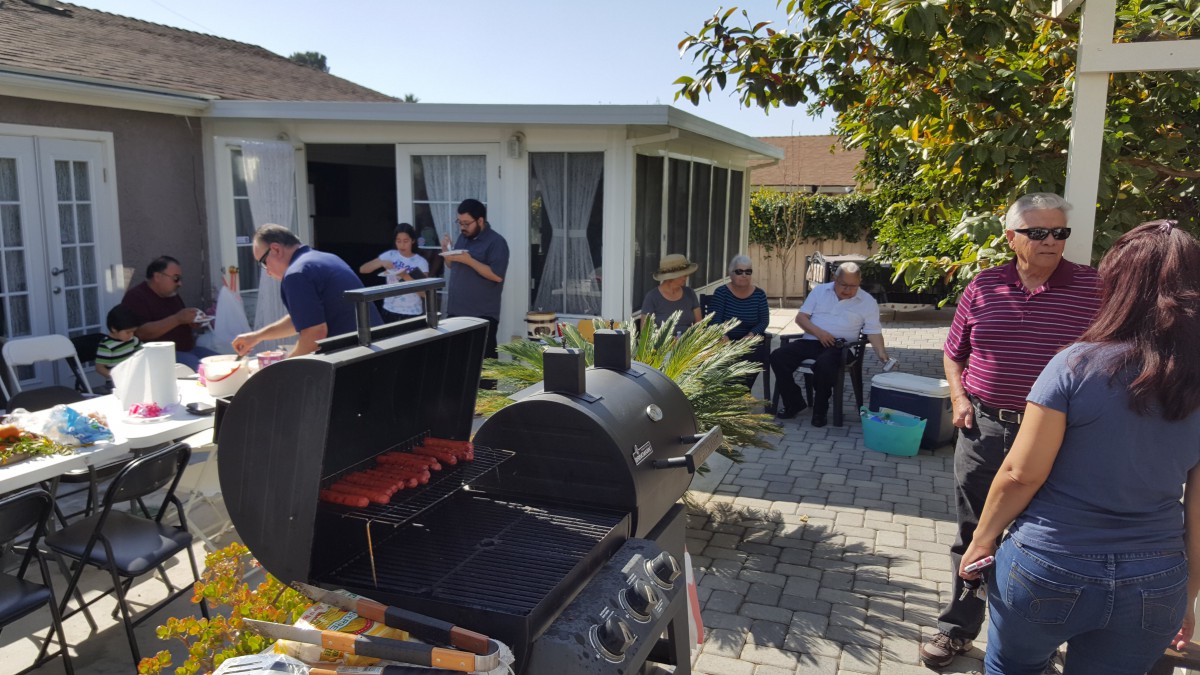 A group of people enjoying a backyard barbecue together.