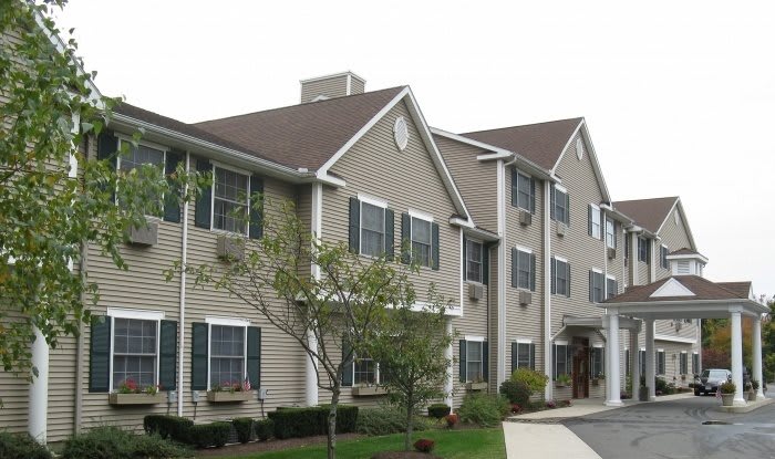 A residential apartment building with multiple windows and a neatly maintained landscape.