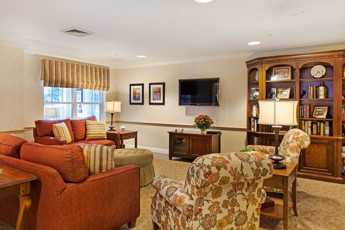 A cozy living room with a sofa, armchairs, and a television.