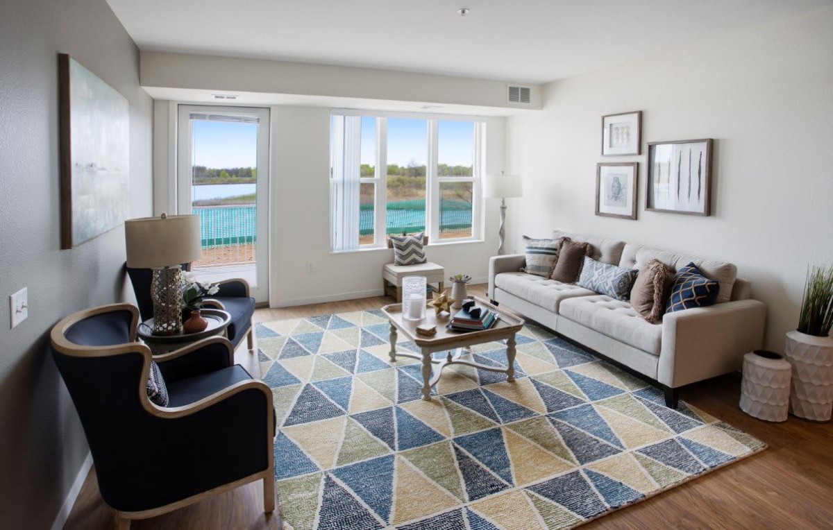 A modern living room with stylish furniture and a scenic view through the windows.