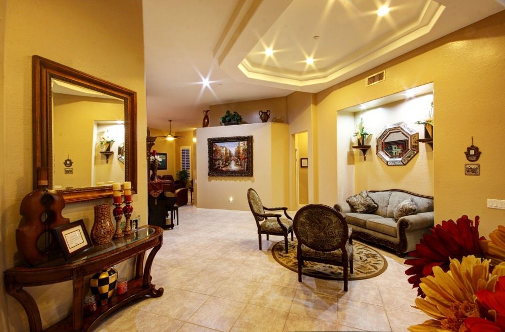 A spacious and elegantly decorated living room featuring comfortable seating, warm lighting, and artistic decor.