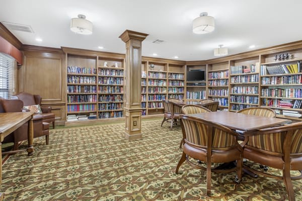 A cozy library with wooden bookshelves and comfortable seating.