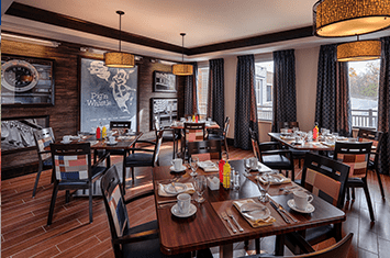 A cozy restaurant dining area with neatly set tables and warm lighting.