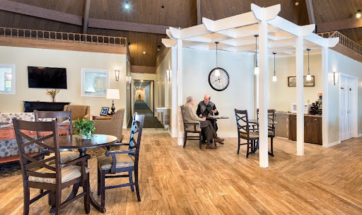 A cozy indoor waiting area with elegant furniture and a warm wooden floor.