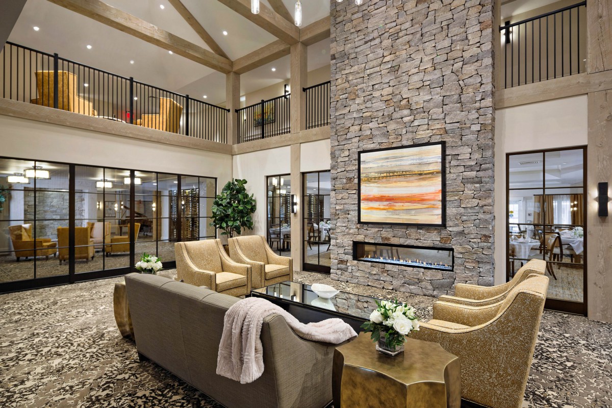 A luxurious living room featuring a stone fireplace and modern furnishings.