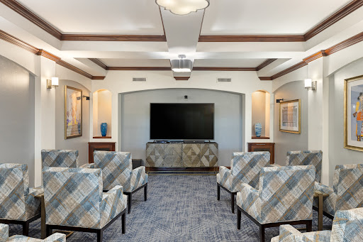 A modern lounge area featuring comfortable seating and a large television.