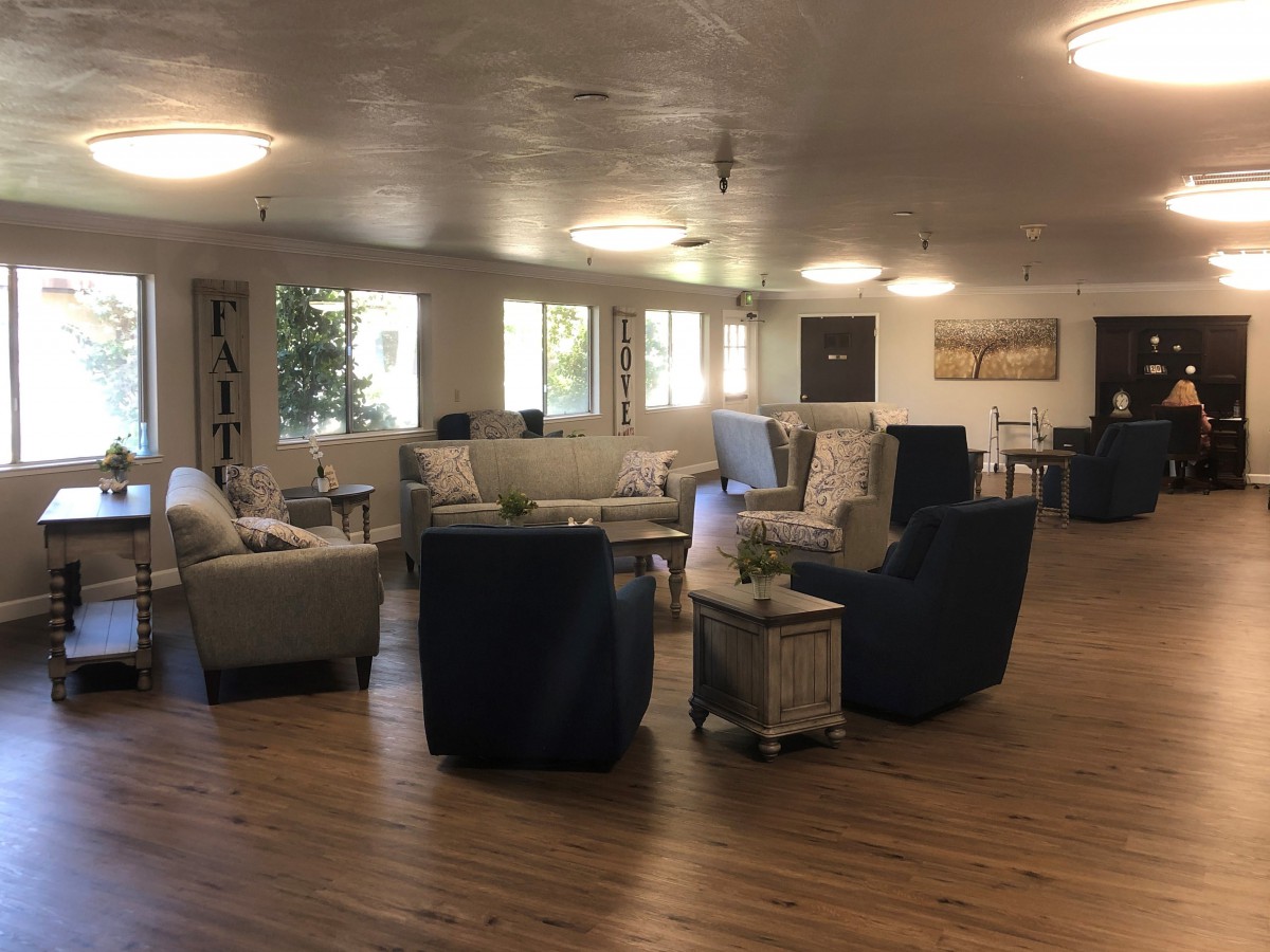 A spacious and modern living room with multiple seating arrangements and large windows providing natural light.
