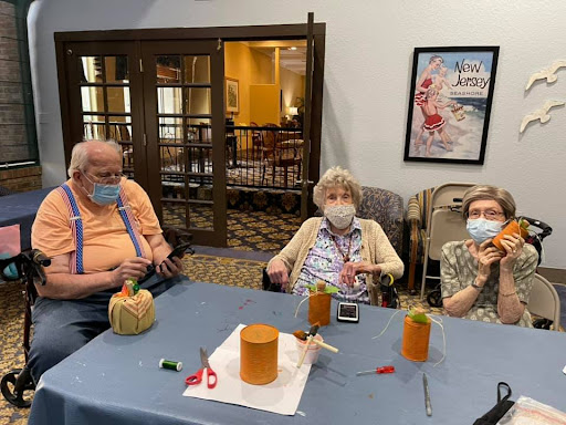 Seniors enjoying a crafting session while decorating pumpkins.