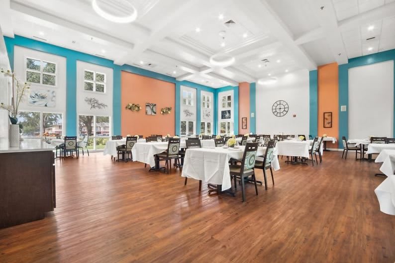 A spacious and elegantly decorated dining room with neatly arranged tables and chairs.