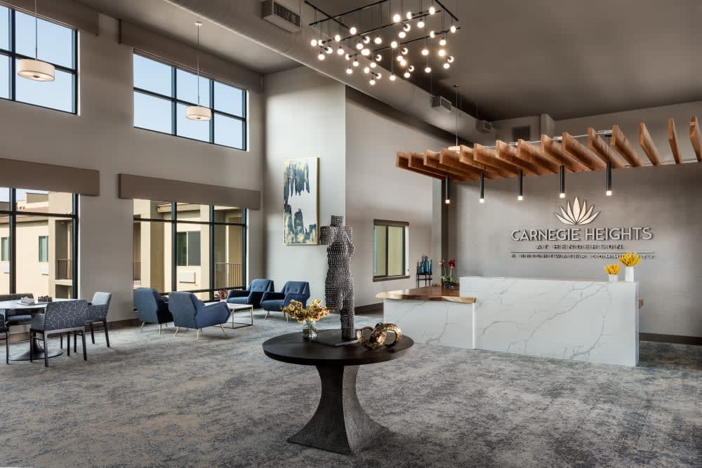 A spacious, modern lobby with contemporary furnishings and a statement chandelier.