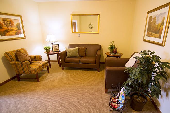 A cozy living room with a sofa, chairs, and decorative elements.