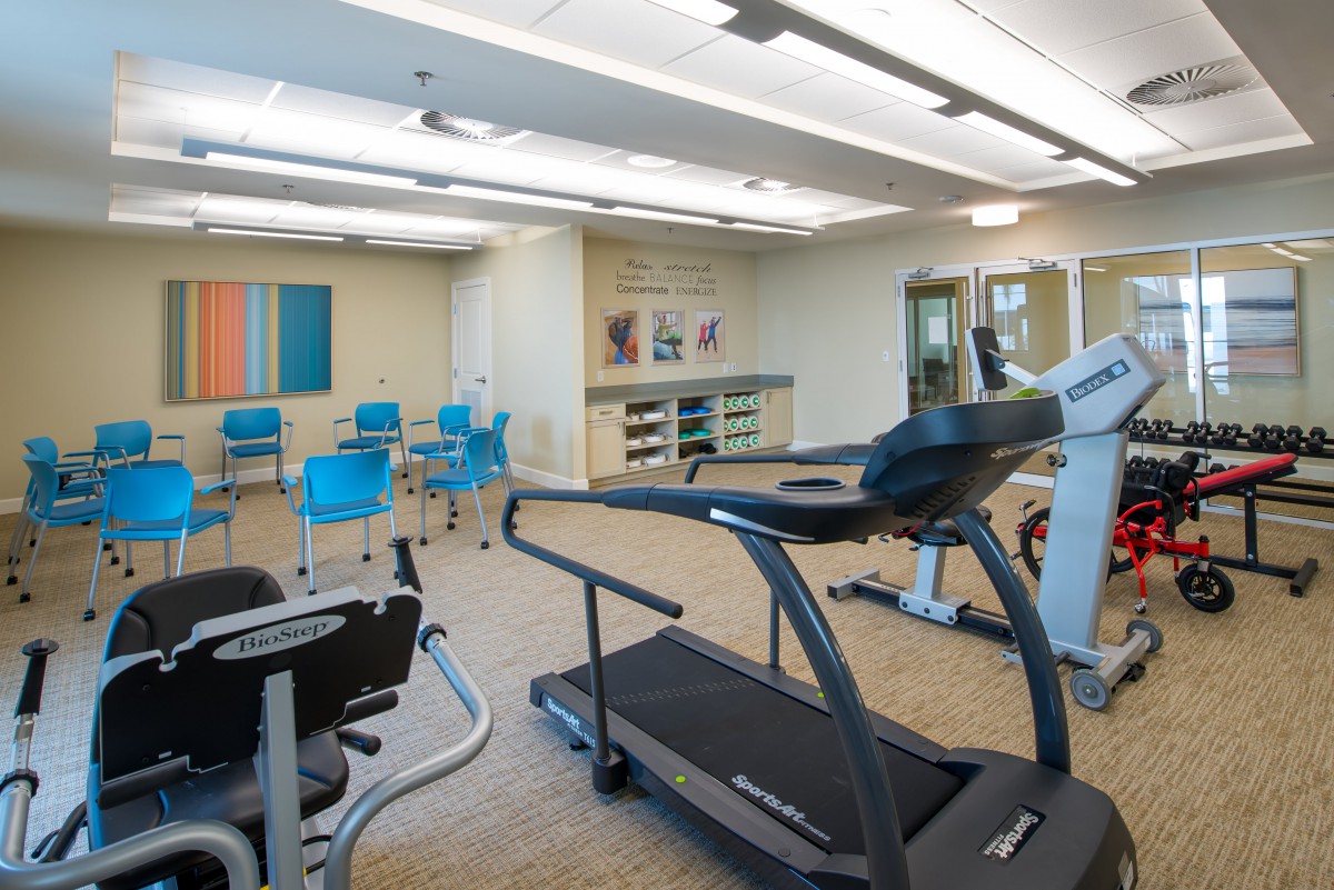 A fitness room equipped with exercise machines and a treadmill.