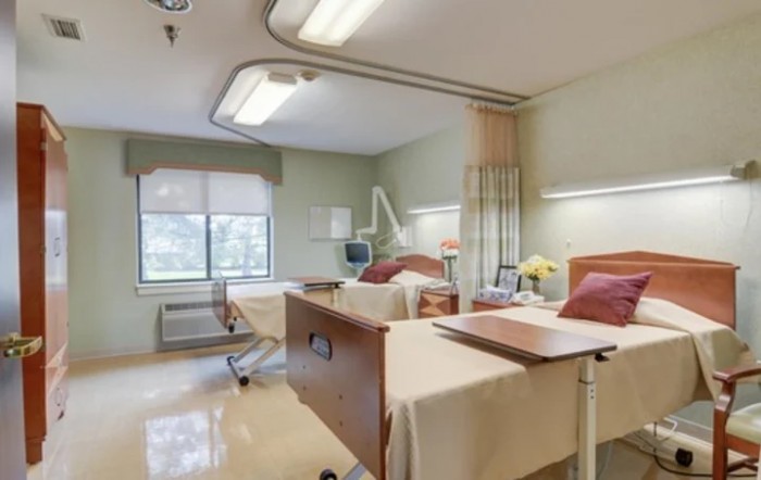 A hospital room with two patient beds and medical equipment.