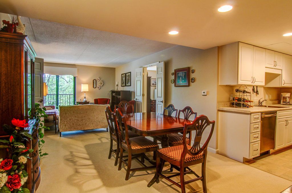 A cozy dining area with a wooden table and chairs, adjacent to a living room space.