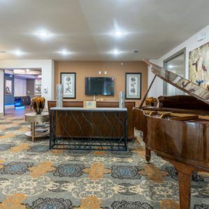 A hotel lobby featuring elegant decor, a grand piano, and stylish furnishings.