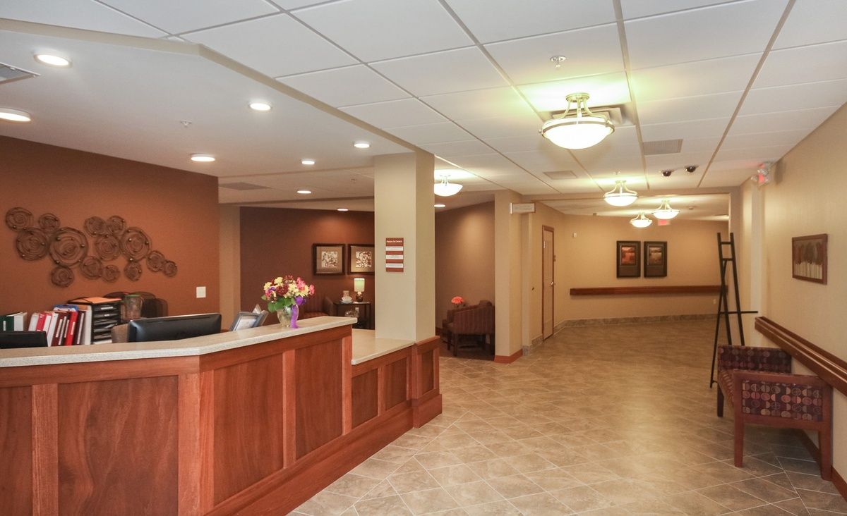 A lobby with a reception desk and hallway leading to other areas.