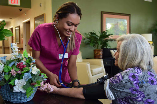 A nurse checks the blood pressure of an elderly patient in a warm and inviting healthcare environment.
