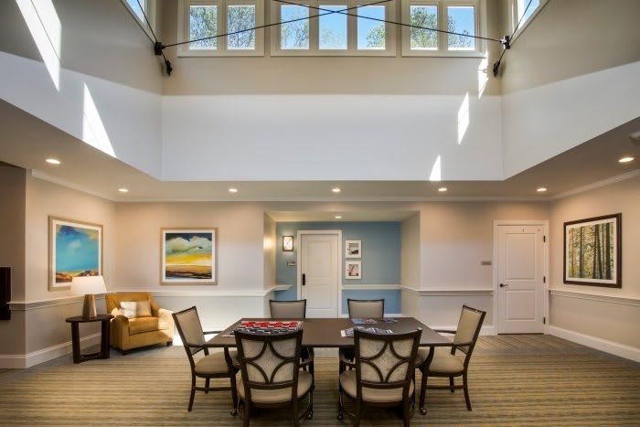 A well-lit dining area with elegant furniture and decorative artwork on the walls.