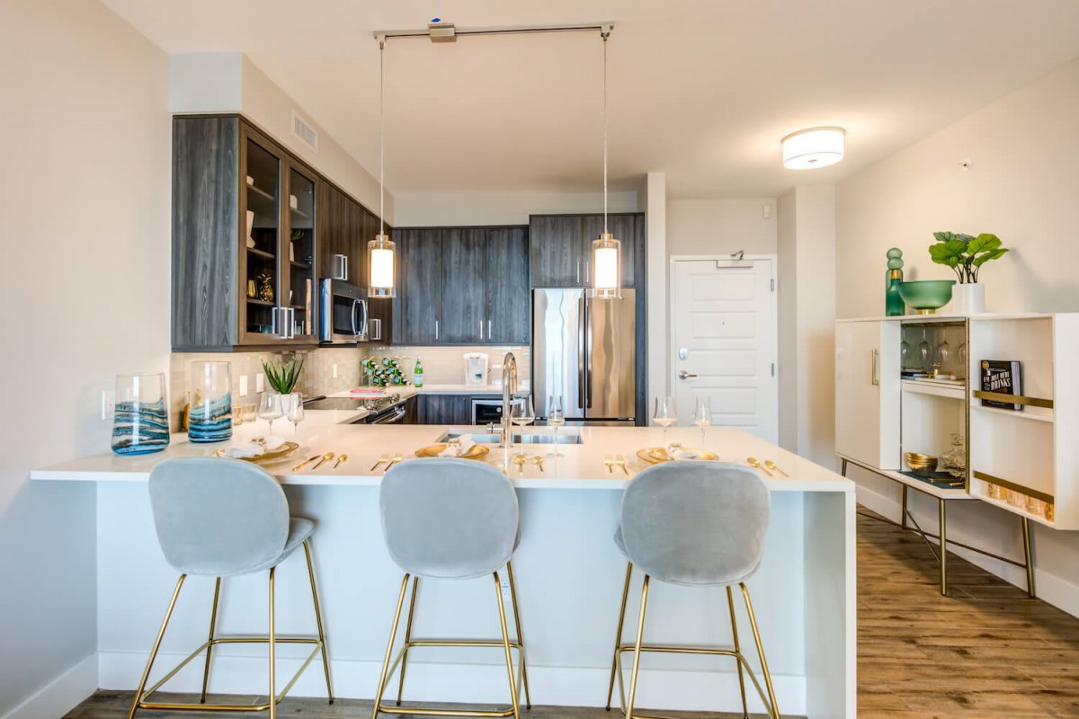 A modern kitchen with a central island and stylish pendant lighting.