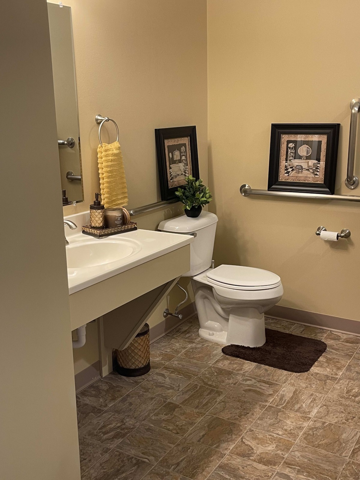 A well-decorated bathroom with a toilet, sink, and wall art.