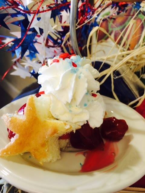 A festive dessert with whipped cream, fruit, and a star-shaped pastry, perfect for a celebration.