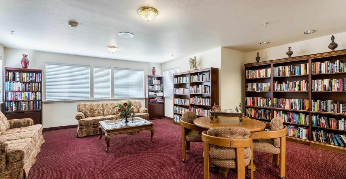 A cozy library room with bookshelves and a seating area.