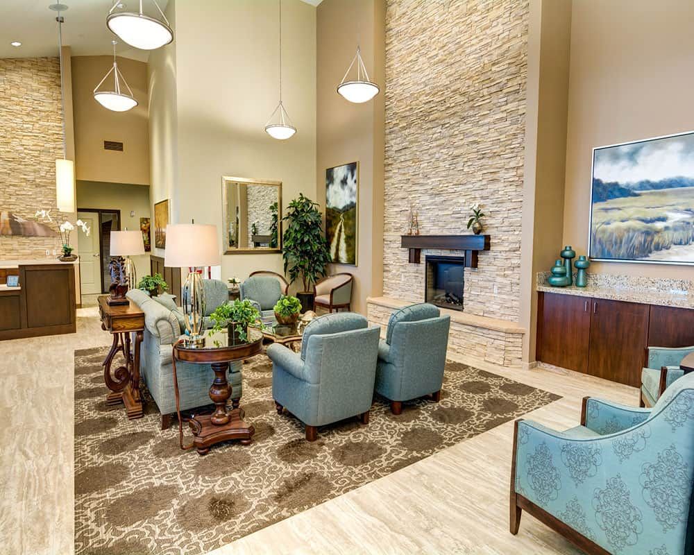 A modern and spacious living room with elegant furniture and a stone fireplace.
