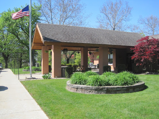A charming building surrounded by lush greenery and featuring an American flag.
