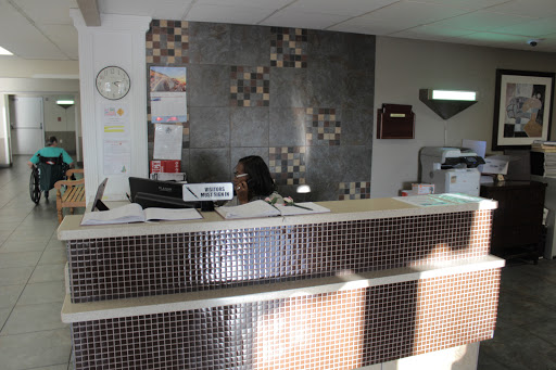 A reception area with a staff member at the desk, surrounded by office decor.