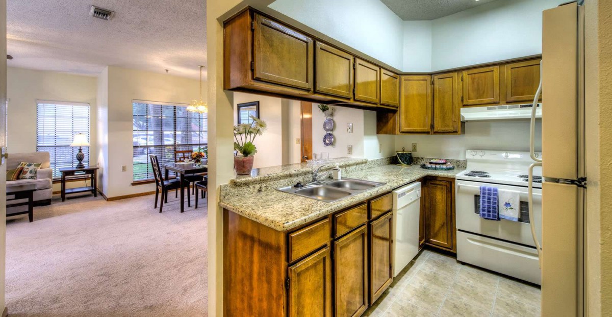 A cozy kitchen with wooden cabinets and a granite countertop.