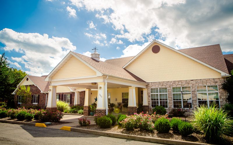 A charming residential building with a well-maintained garden and a clear blue sky overhead.